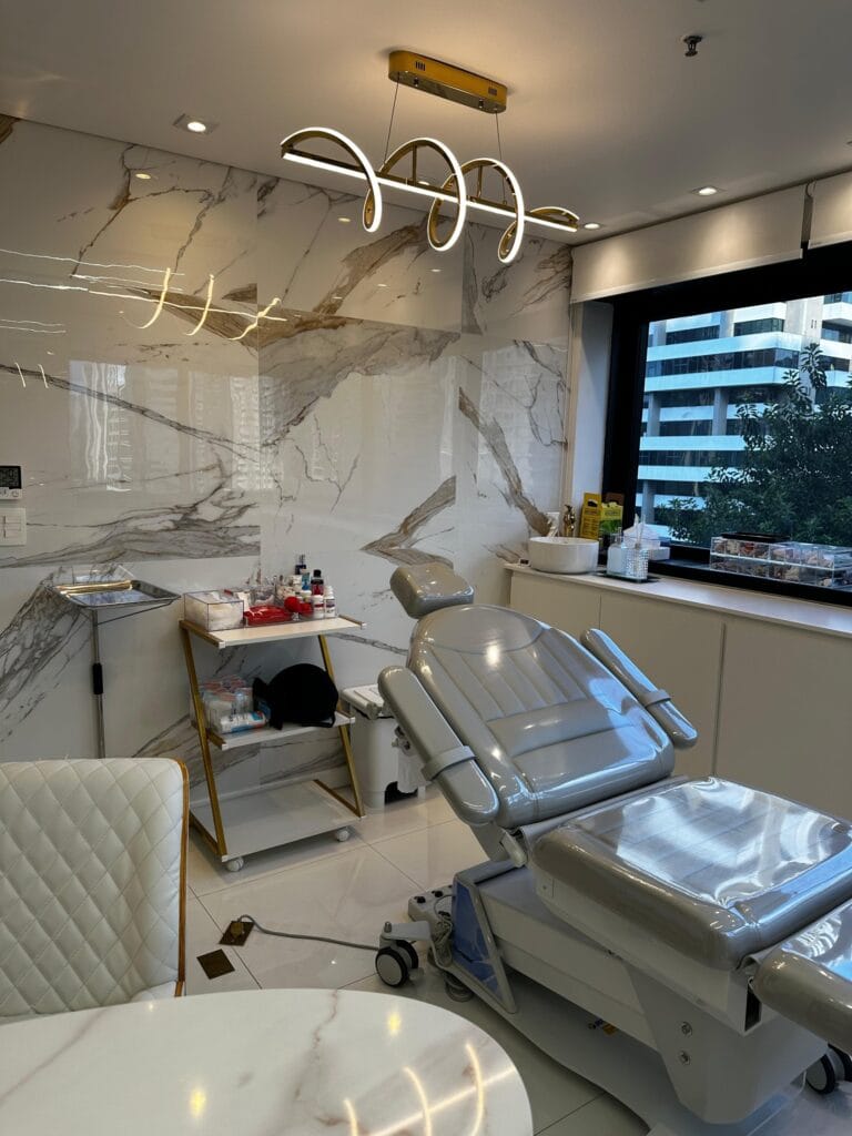 Sala de procedimentos dermatológicos com maca elétrica no consultório em Moema